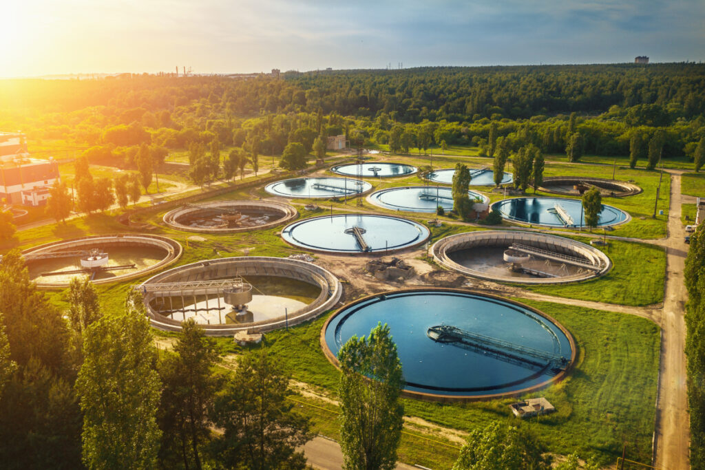 Aerial view of a large water and wastewater treatment plant with circular clarifiers.
