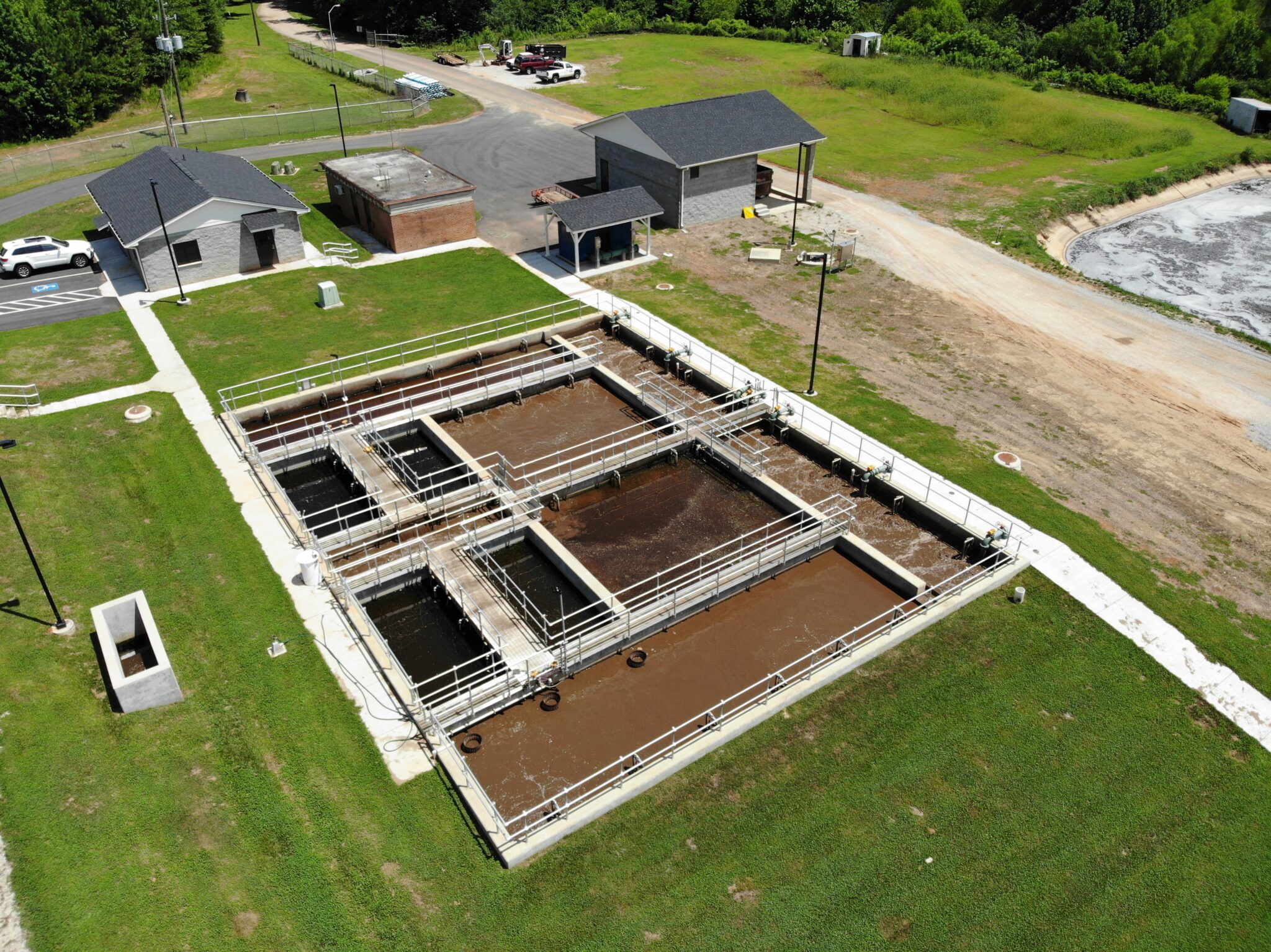 Aerial view of a wastewater treatment plant with multiple rectangular tanks.